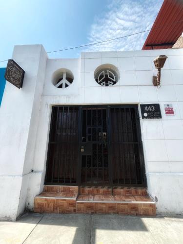 a white building with black doors and two windows at Ugarte Street in Trujillo