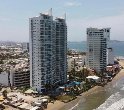 an aerial view of two tall buildings on the beach at Apartamento pie de playa in Mazatlán