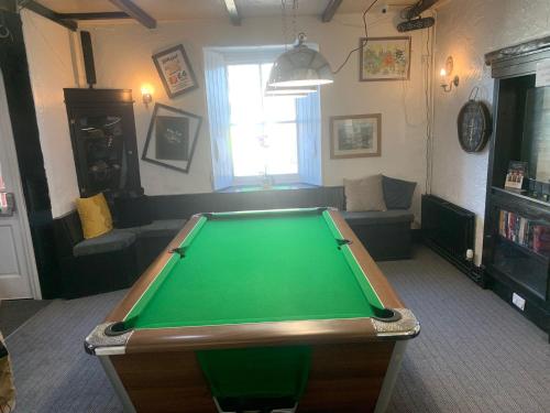a living room with a green pool table at The Chisel Coach House at The Bettle and Chisel in Delabole