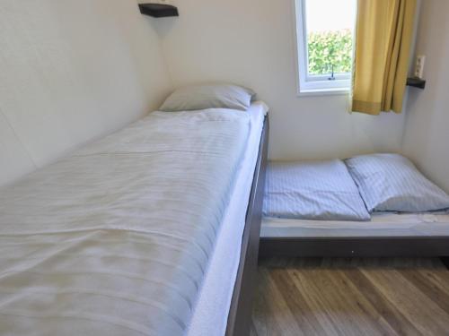 a small bedroom with two beds and a window at t Kaatsheuveltje 3 in Sprang-Capelle