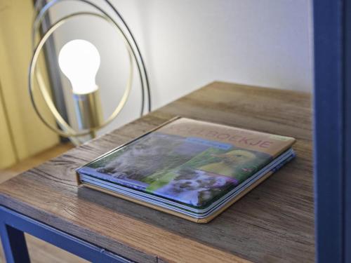 a book sitting on a table next to a lamp at t Kaatsheuveltje 3 in Sprang-Capelle