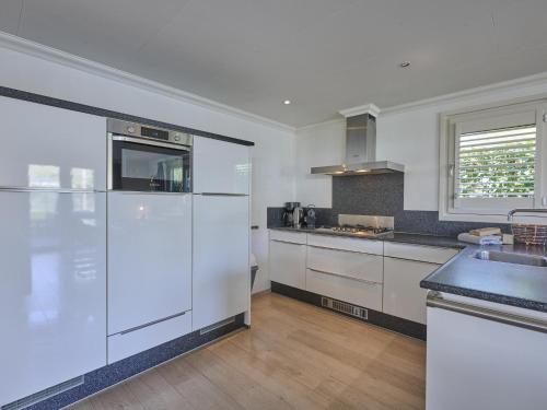 a kitchen with a white refrigerator and a sink at t Kaatsheuveltje 4 in Sprang-Capelle