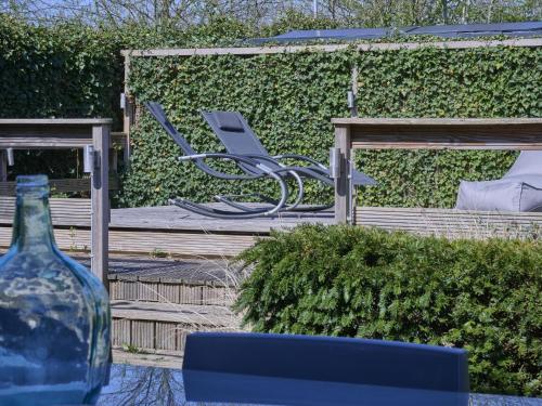 a chair and a vase sitting on a wooden deck at t Kaatsheuveltje 4 in Sprang-Capelle
