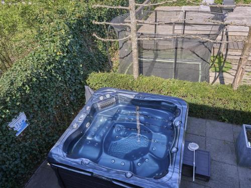 a blue suitcase sitting on the ground next to a hedge at t Kaatsheuveltje 4 in Sprang-Capelle