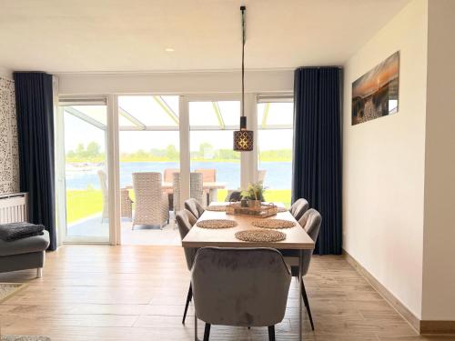 a dining room with a table and chairs with a view at Sonnenschein in Stevensweert