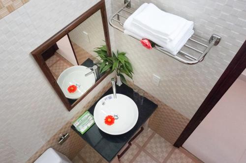 a bathroom with a white sink and a mirror at Phoenix Homestay in Hoi An