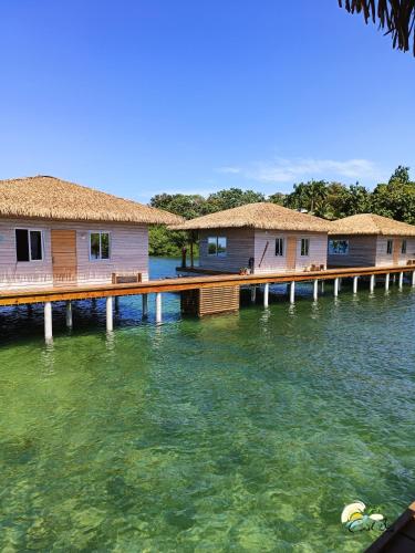 a row of houses on a dock in the water at CoralBay Bungalows Solarte in Solarte