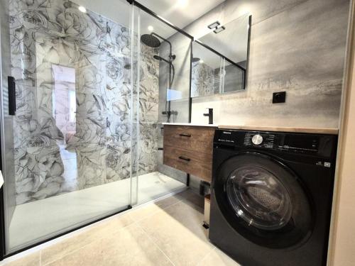 La salle de bains est pourvue d'un lave-linge et d'une douche. dans l'établissement Résidence Villa Lamartine - Coup de coeur pour ce magnifique 3 pièces ! MAE-3843, à Aix-les-Bains