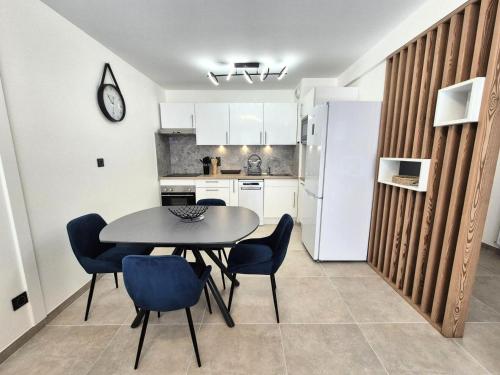 une cuisine avec une table et des chaises dans une pièce dans l'établissement Résidence Villa Lamartine - Coup de coeur pour ce magnifique 3 pièces ! MAE-3843, à Aix-les-Bains