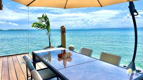 a table with a teddy bear sitting on top of the ocean at CoralBay Bungalows Solarte in Solarte