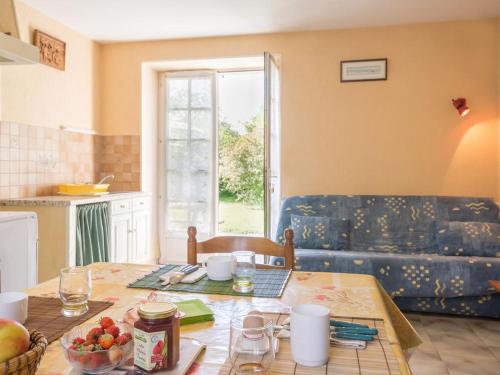 un salon avec une table et un canapé bleu dans l'établissement Gîte au calme avec terrasse, barbecues, wifi, à 20 min de Nantes et la mer, animaux acceptés - FR-1-306-830, à Rouans