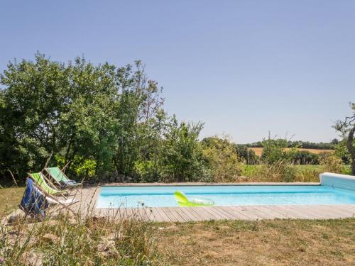- une piscine dans une cour avec 2 chaises longues dans l'établissement Gîte écolabel entre Angers et Loire, piscine chauffée, jardin clos, calme et charme authentique - FR-1-306-847, à La Chapelle-Saint-Sauveur