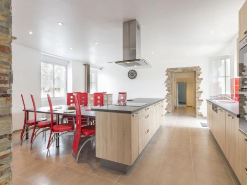 une cuisine avec une table à manger et des chaises rouges dans l'établissement Gîte rénové près de la mer avec jardin clos, cheminée, Wifi et équipements bébé inclus. - FR-1-306-879, à Saint-Hilaire-de-Chaléons