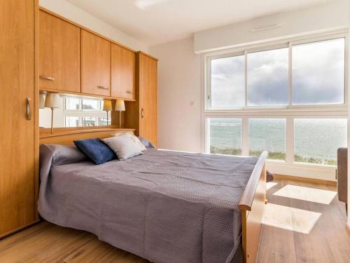ein Schlafzimmer mit einem Bett und einem großen Fenster in der Unterkunft Appartement face à la plage avec loggia, cour, wifi et barbecue - Piriac-sur-Mer - FR-1-306-844 in Piriac-sur-Mer