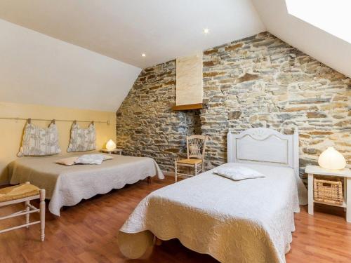 a bedroom with two beds and a stone wall at Charmant Gîte avec Jardin Clos au Cœur du Parc de Brière, Proche La Baule et Guérande - FR-1-306-863 in La Chapelle-des-Marais