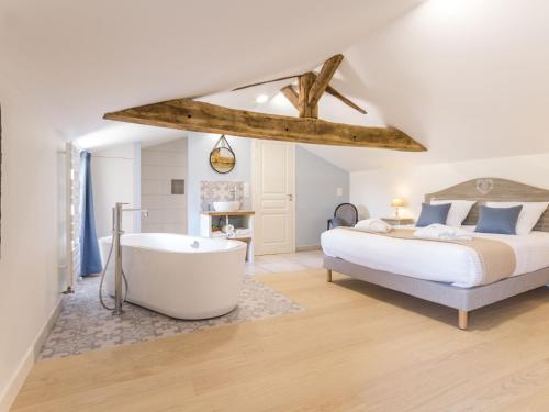 a bedroom with a bed and a bath tub at Élégant Gîte Rural avec Piscine Intérieure Chauffée près de Nantes - FR-1-306-913 in Châteauthébaud