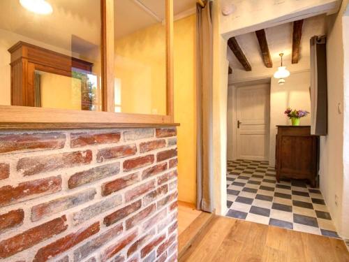 a room with a brick wall and a checkered floor at Maison Authentique Bord de Rivière avec Jardin Privatif - Gîte de Pêche, Animaux sur Demande - FR-1-306-886 in Moisdon-la-Rivière