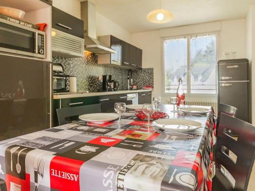 une cuisine avec une table avec des assiettes et des verres à vin dans l'établissement Gîte en campagne avec jardin privatif, près du Parc de Brière, tout confort, 3 chambres, Wi-Fi inclus - FR-1-306-893, à Missillac