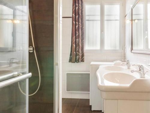 une salle de bain blanche avec un lavabo et une douche dans l'établissement Gîte calme entre Pornic et Nantes avec jardin, terrasse, jeux, WiFi, et équipements pour enfants - FR-1-306-1022, à Saint-Hilaire-de-Chaléons