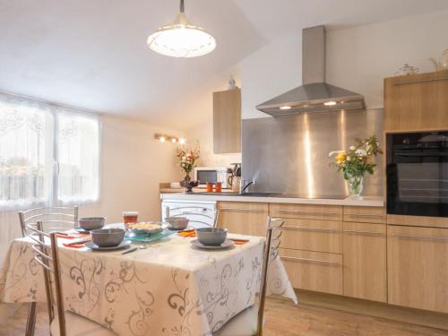 une cuisine avec une table recouverte d'une nappe dans l'établissement Gîte Confortable entre Nantes et la Mer avec Parking Sécurisé et Coin Détente Privé - FR-1-306-885, à Saint-Philbert-de-Grand-Lieu