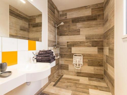 a bathroom with a white sink and wooden walls at Grande maison en bois avec parc, terrasse, jeux et équipements modernes entre Nantes et Pornic - FR-1-306-1051 in Port-Saint-Père