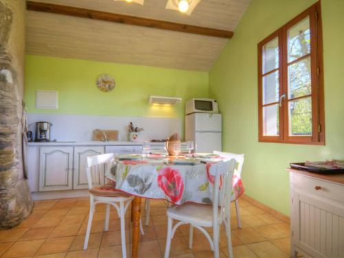 une cuisine avec une table et des chaises dans une pièce dans l'établissement Moulin rénové avec jardin clos près de Pornic - FR-1-306-872, à Pornic