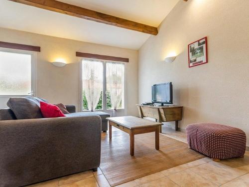 un salon avec un canapé et une télévision dans l'établissement Gîte familial avec jardin clos, à 25 km de Nantes, WiFi, vélos et jeux pour enfants. - FR-1-306-953, à Rouans