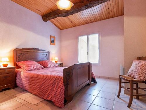 a bedroom with a bed with a red comforter and a window at Gîte familial avec jardin clos, à 25 km de Nantes, WiFi, vélos et jeux pour enfants. - FR-1-306-953 in Rouans