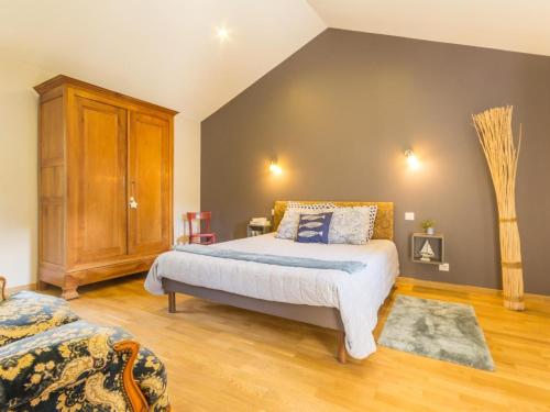 ein Schlafzimmer mit einem Bett und einem Holzschrank in der Unterkunft Spacieux écogîte en pierre avec jardin clos, proche de l'océan et des plages, tout confort - FR-1-306-1032 in Saint-Brevin-les-Pins