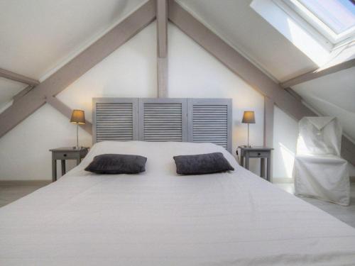 ein Schlafzimmer mit einem großen weißen Bett mit zwei Kissen in der Unterkunft Charmant gîte face mer avec balcon privé, proche Pornic, tout confort assuré - FR-1-306-1025 in Saint-Michel-Chef-Chef