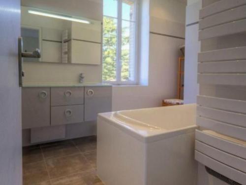 ein weißes Badezimmer mit Badewanne und Fenster in der Unterkunft Charmant gîte face mer avec balcon privé, proche Pornic, tout confort assuré - FR-1-306-1025 in Saint-Michel-Chef-Chef