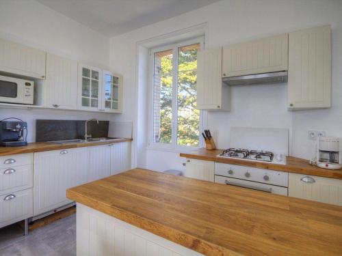 une cuisine avec des armoires blanches et un comptoir en bois dans l'établissement Charmant gîte face mer avec balcon privé, proche Pornic, tout confort assuré - FR-1-306-1025, à Saint-Michel-Chef-Chef