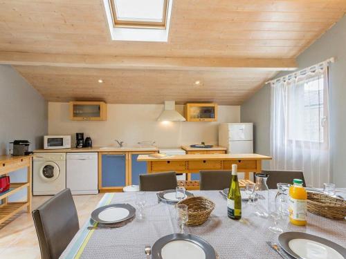 une salle à manger avec une table et une cuisine dans l'établissement Ancien Bâtiment de Ferme Rénové entre Nantes et Pornic avec Jardin et Activités - FR-1-306-1028, à Port-Saint-Père