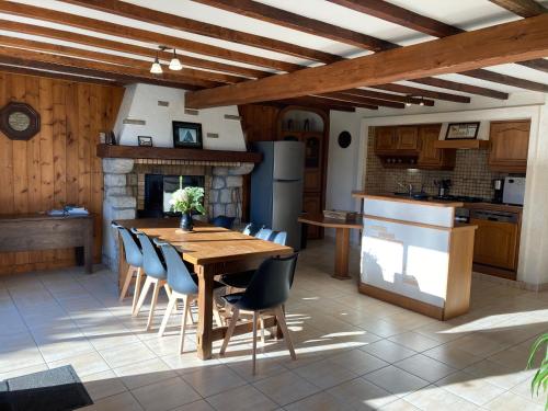 une cuisine avec une table et des chaises en bois dans l'établissement Charme ancien revisité : Gîte spacieux avec grand jardin, équipements complets, près de Guérande. - FR-1-306-1064, à Mesquer
