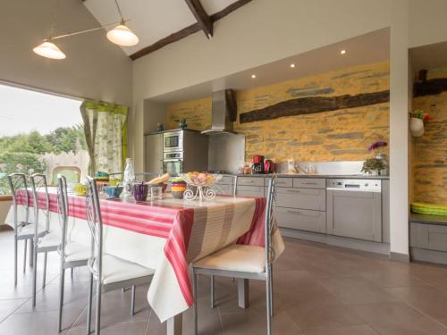 une cuisine avec une table et des chaises dans une cuisine dans l'établissement Gîte rénové avec jardin clos, proche Nantes, idéal famille, accessible PMR, wifi inclus - FR-1-306-1134, à Vay
