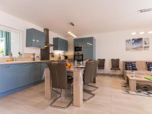 une cuisine avec des armoires bleues et une table et des chaises dans l'établissement Appartements à Piriac-sur-Mer, plage, wifi, animaux acceptés - FR-1-306-1155, à Piriac-sur-Mer