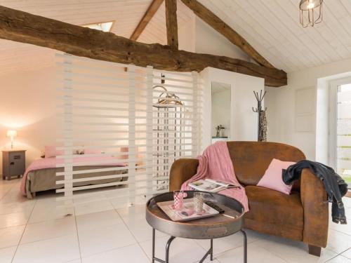 un salon avec un canapé et un lit dans l'établissement Gîte paisible à la campagne près de Pornic, jardin commun, wifi, idéal pour détente et loisirs - FR-1-306-1069, à Pornic