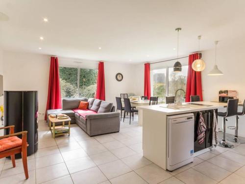 Il comprend une cuisine et un salon avec des rideaux rouges. dans l'établissement Maison contemporaine à Nozay avec jardin clos, proche Nantes : 3 chambres, Wi-Fi, garage vélos/motos - FR-1-306-1178, à Nozay