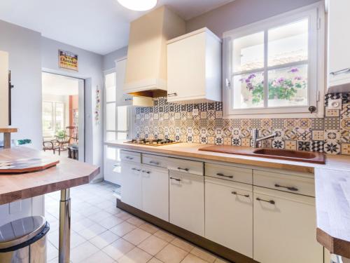 a kitchen with white cabinets and a sink at Maison de pêcheurs avec terrasse en bord de Loire, wifi, vélos et équipé bébé - FR-1-306-1177 in Saint-Florent-le-Vieil