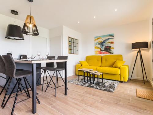 un salon avec un canapé jaune et une table dans l'établissement Gîtes avec piscine chauffée proche plage. Jardin, spa, BBQ, Wifi. Ch. bébé incluse - FR-1-306-1209, à Préfailles