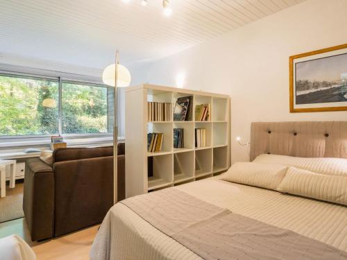 - une chambre avec un lit, un canapé et une étagère dans l'établissement Gîte Contemporain avec Jardin et Parking à La Chapelle-sur-Erdre - FR-1-306-1309, à La Chapelle-sur-Erdre