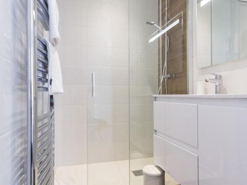 a white bathroom with a shower and a sink at Gîtes avec piscine chauffée, SPA, proche plage et commerces, jardin privatif et tout compris - FR-1-306-1207 in Préfailles