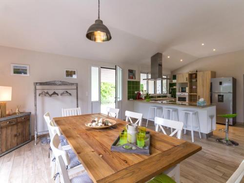 une cuisine et une salle à manger avec une table et des chaises en bois dans l'établissement Gîte paisible avec grand jardin près du lac, ping-pong, vélo, climatisation, proche de Nantes et plages - FR-1-306-1056, à Saint-Philbert-de-Grand-Lieu