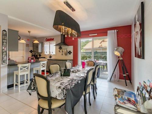 une salle à manger avec une table et une cuisine dans l'établissement Maison Neuve en Bord de Mer avec Jardin Boisé, Wifi, et Équipements Complets - FR-1-306-1096, à Saint-Brévin-les-Pins