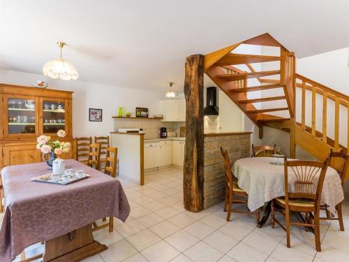une cuisine et une salle à manger avec une table et un escalier dans l'établissement Gîte familial au calme avec jardin, près de Nantes et St Nazaire, activités pour petits et grands - FR-1-306-1119, à Plessé