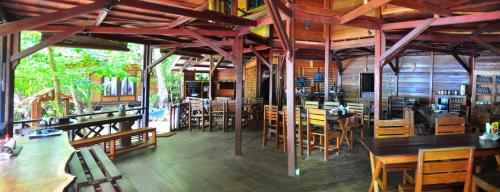 a restaurant with wooden tables and chairs in a room at Raja Ampat Dive Resort in Tapokreng