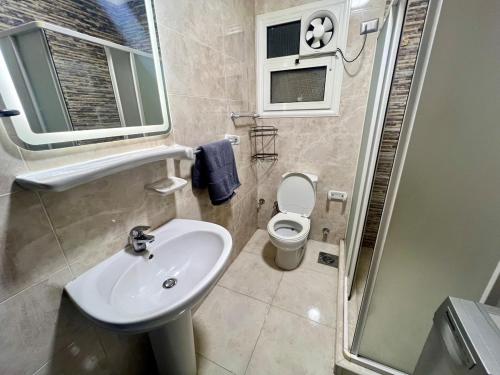 une salle de bain avec un lavabo, des toilettes et une douche dans l'établissement Madinaty Luxury Escape 2BR, à Madinaty