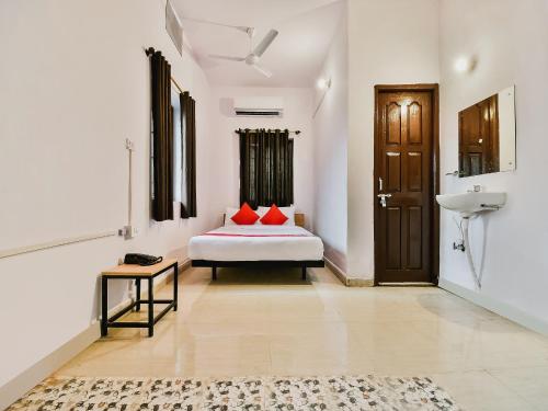 a bedroom with a bed with red pillows and a sink at Super Hotel O Capital Pearl in Patna