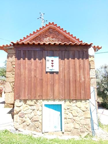 a stone building with a cross on top of it at Casas Coração in Codeçoso
