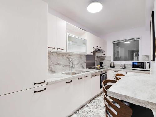 une cuisine blanche avec un évier et un comptoir dans l'établissement Charming apartment -1BR-4P- Arc de Triomphe, à Paris